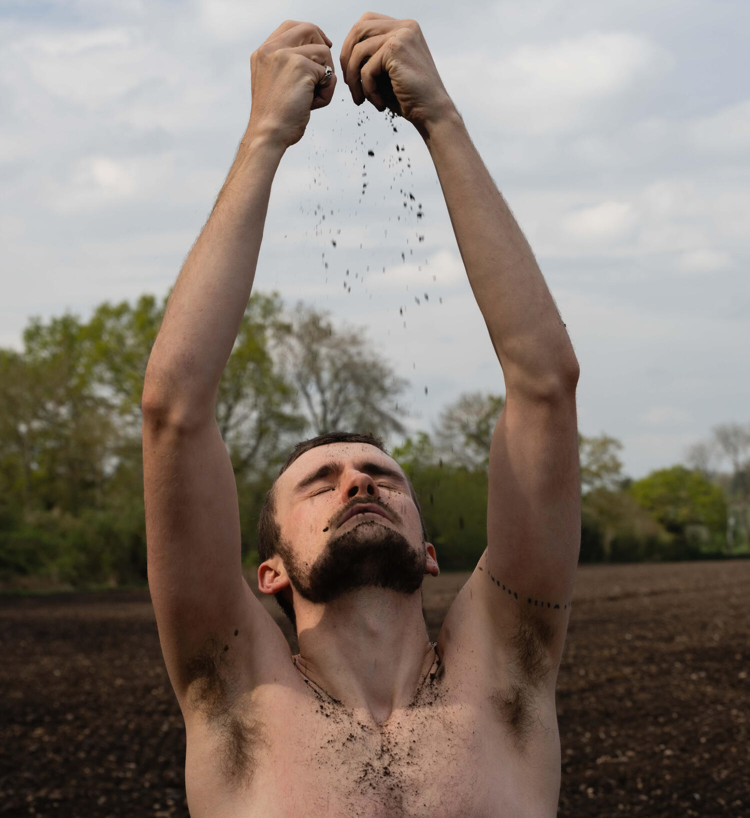 Shaun Hill Embodied Woodland Poet Shaun performing somatic movement behind the leaves of a tree.